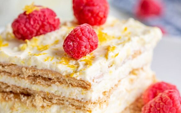 A slice of lemon icebox cake with scattered raspberries.