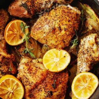 Lemon roasted chicken pieces with lemon slices.