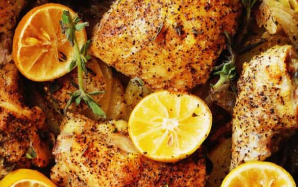 Lemon roasted chicken pieces with lemon slices.