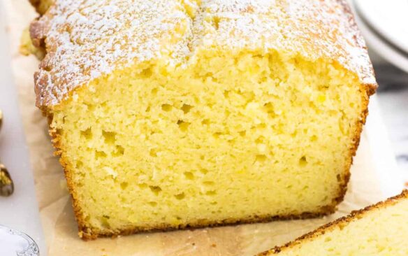 A loaf of lemon yogurt cake on a cutting board.