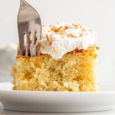 close up image of pineapple cake with fork poking into the cake