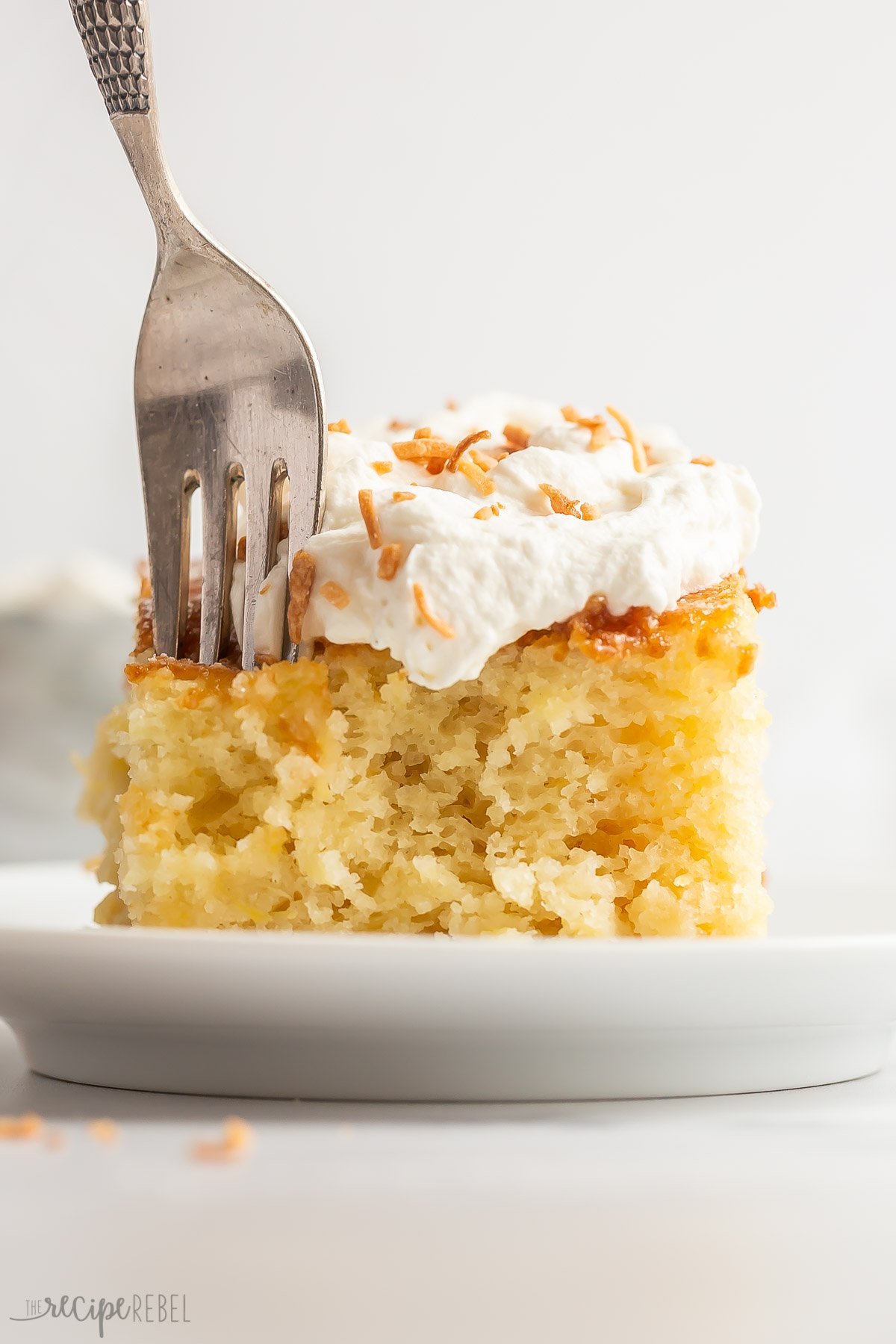 close up image of pineapple cake with fork poking into the cake