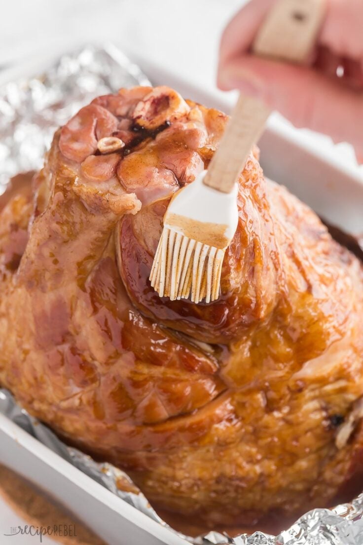 spiral ham being brushed with glaze after baking