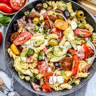 Top view of antipasto pasta salad in a black serving bowl.