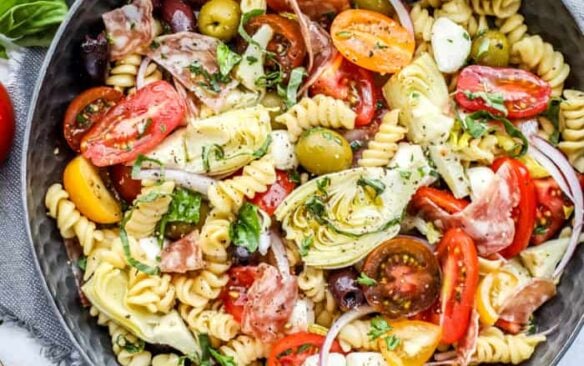 Top view of antipasto pasta salad in a black serving bowl.