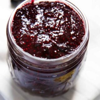A mason jar filled with homemade blueberry chia jam.