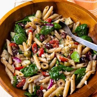 Mediterranean pasta salad in a large wooden bowl.
