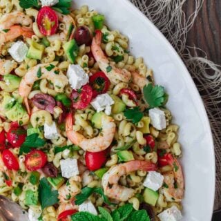 Mediterranean shrimp pasta salad served on a white platter.