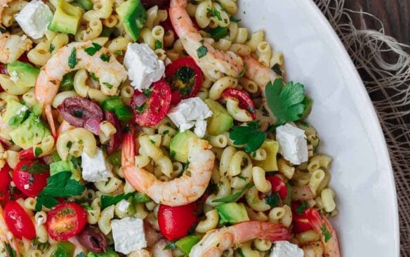 Mediterranean shrimp pasta salad served on a white platter.