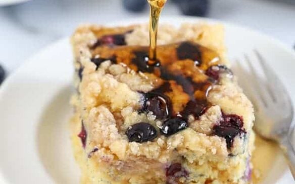 A serving of pancake casserole on a plate, drizzled with maple syrup.