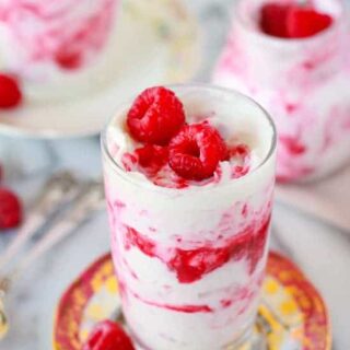 Raspberry rhubarb fool served in glasses and topped with fresh raspberries.