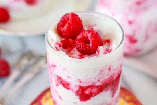Raspberry rhubarb fool served in glasses and topped with fresh raspberries.