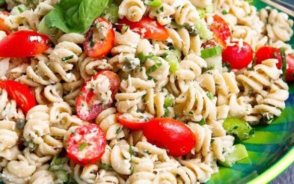 Tuna pasta salad served on a plate garnished with basil leaves.