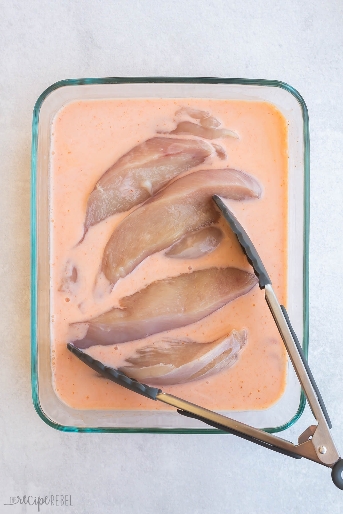 chicken tenders soaking in buttermilk and sriracha mixture