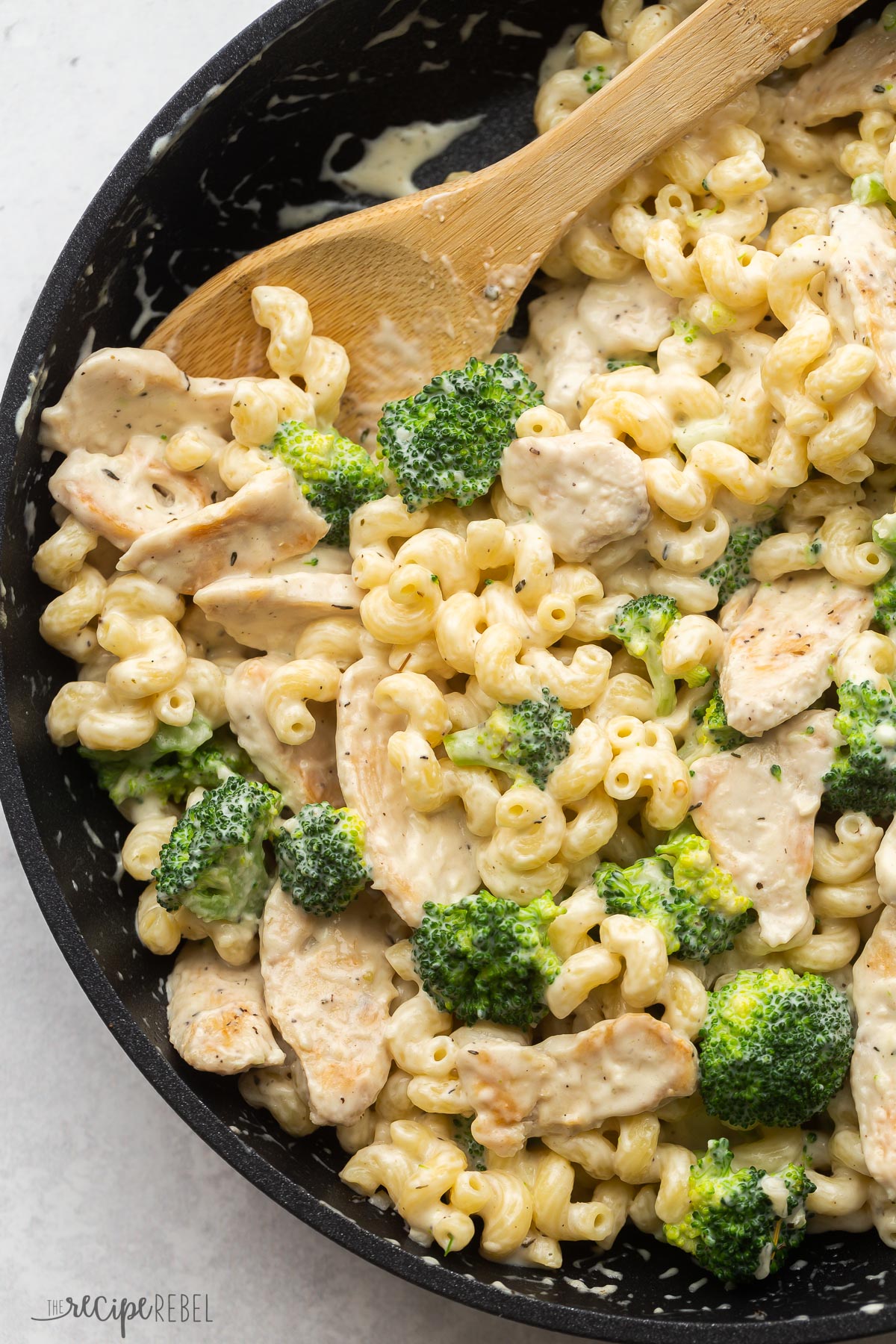 close up image of wooden spoon scooping chicken broccoli alfredo