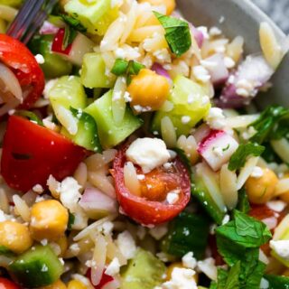 Close up of a bowl of orzo pasta salad.