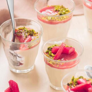 Glasses of garnished rhubarb panna cotta.