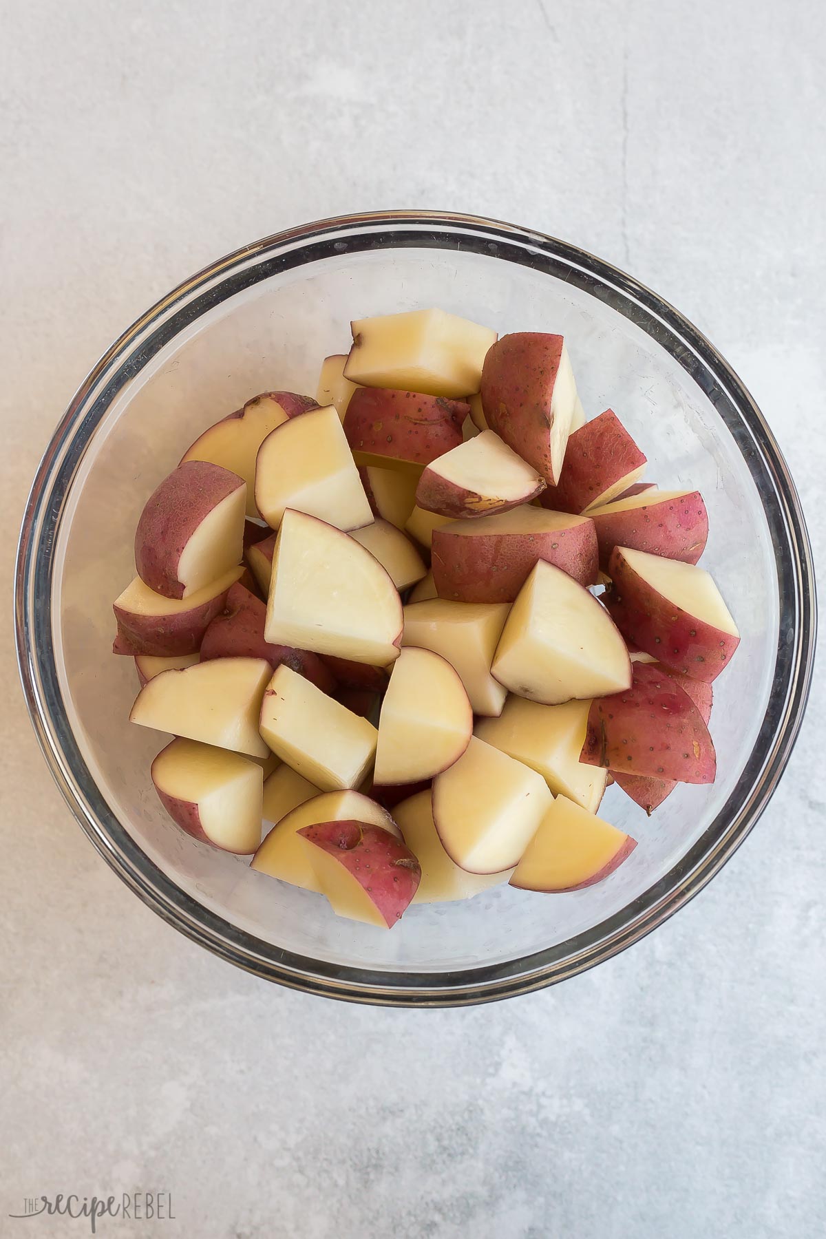 large glass bowl filled with chunks of raw potato