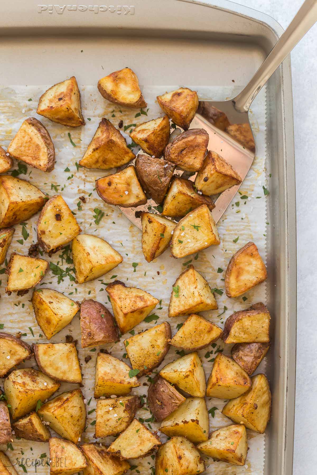 overhead image of roasted red potatoes on baking sheet lined with parchment