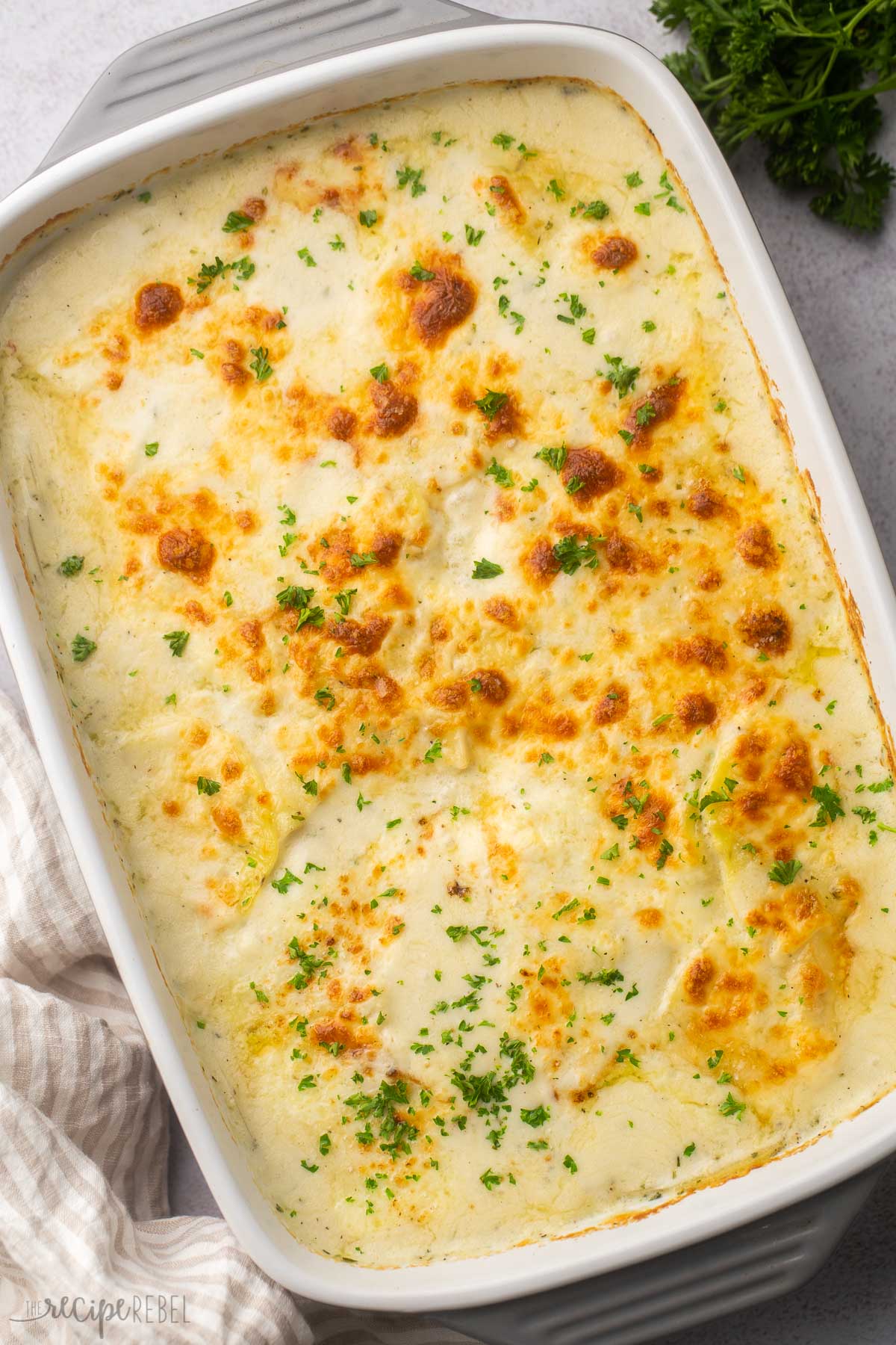 overhead image of pan of scalloped potatoes with fresh parsley.