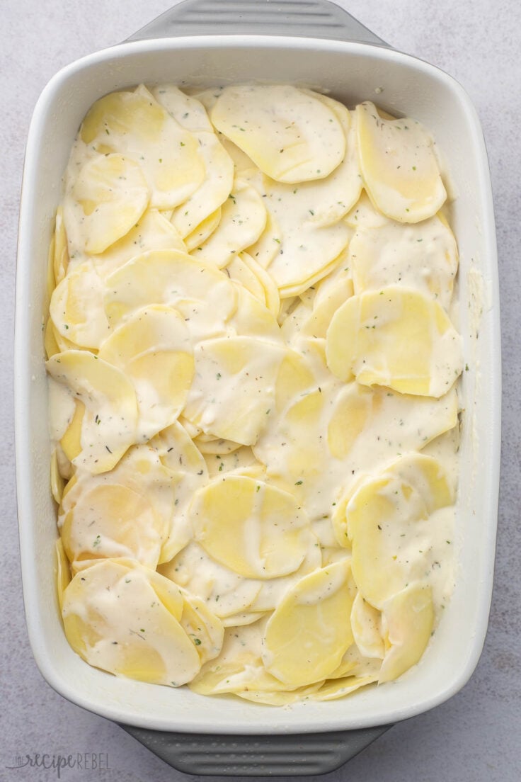 sauce spread over sliced potatoes in baking dish.