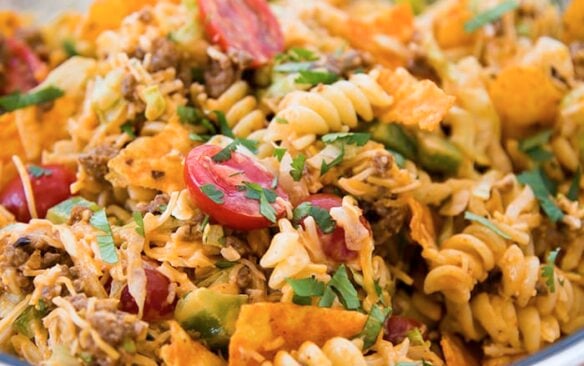 A clear bowl full of taco pasta salad.