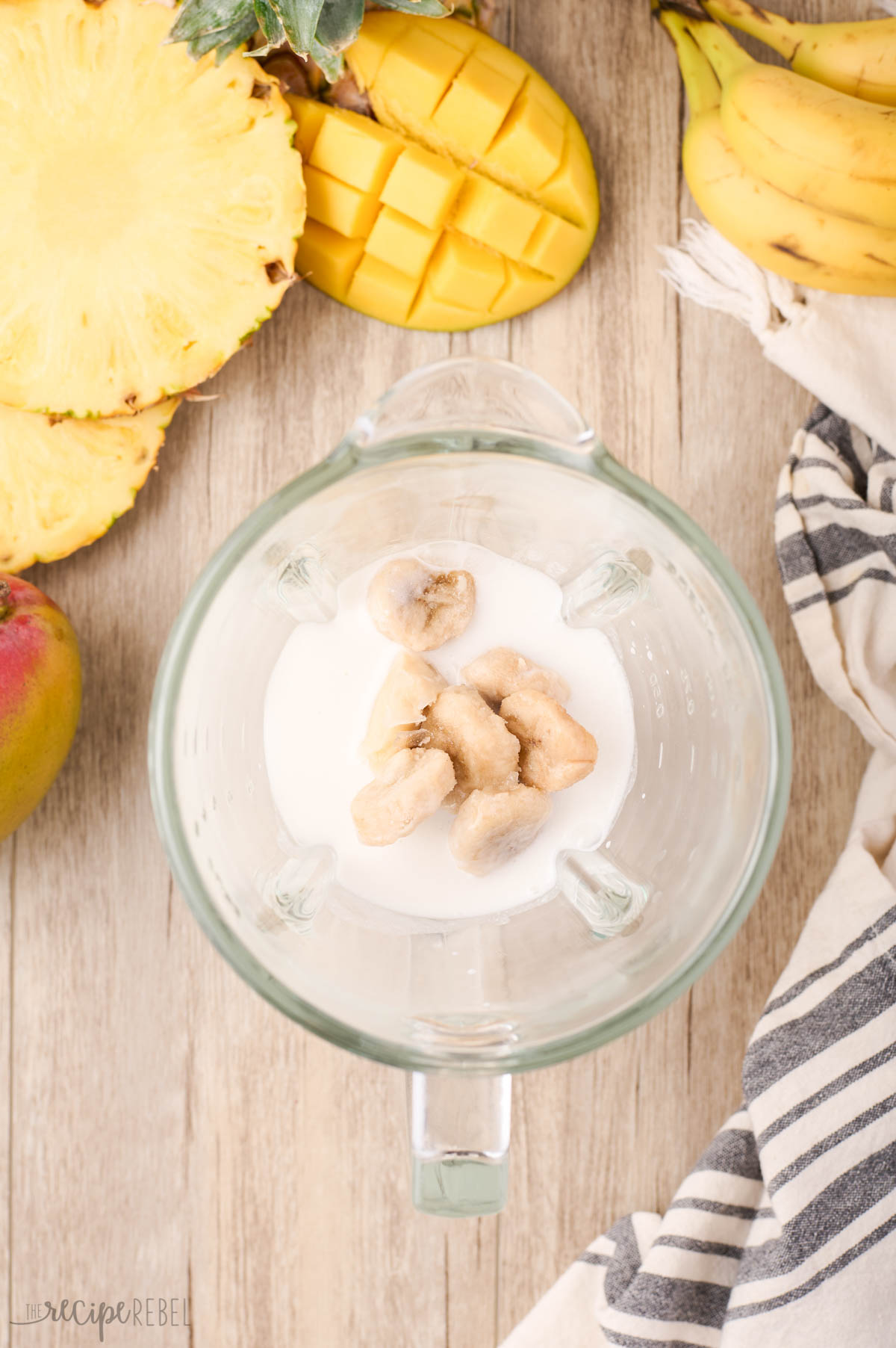 frozen bananas added to blender to make tropical smoothie