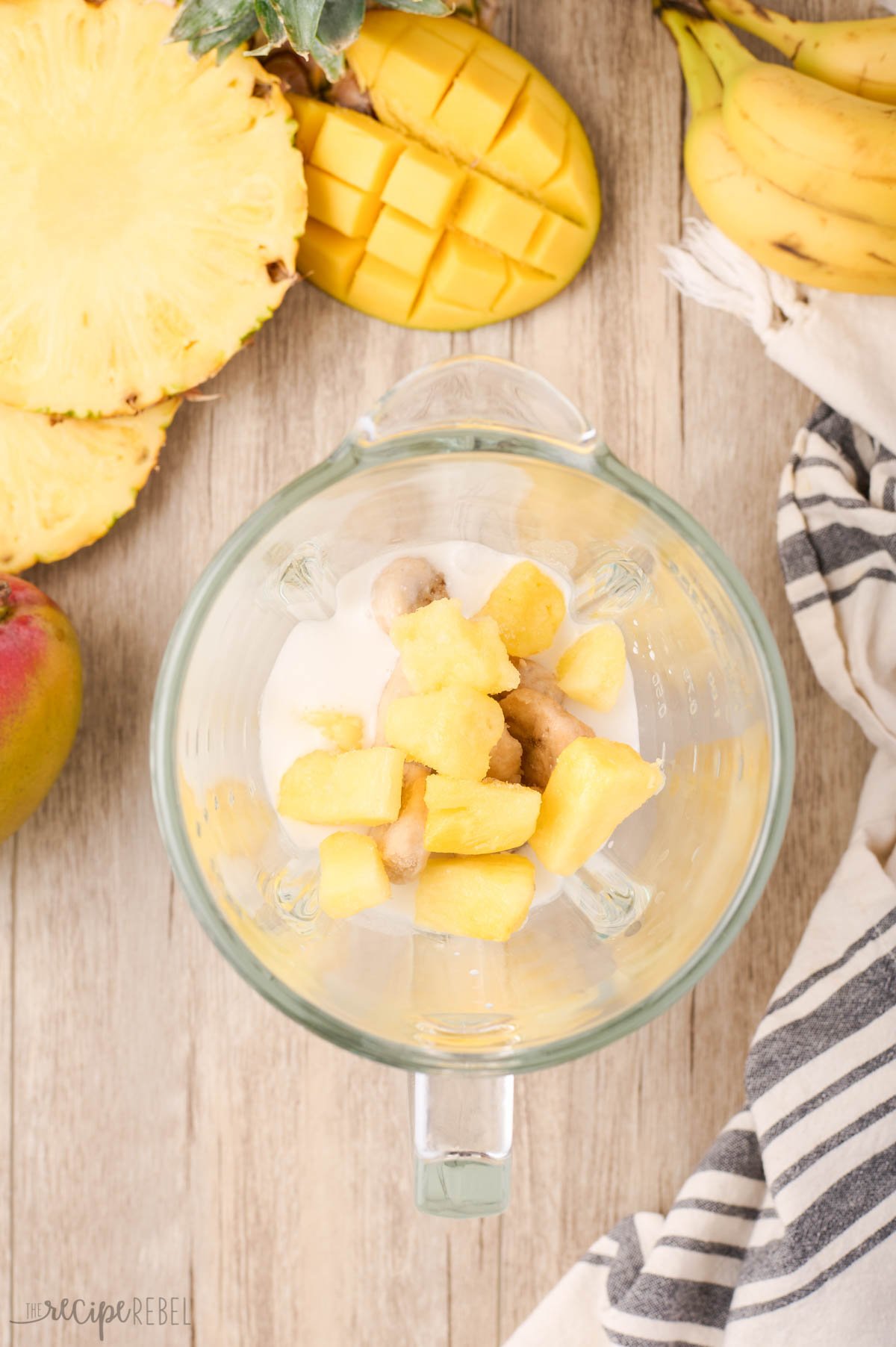 frozen pineapple added to blender to make tropical smoothie