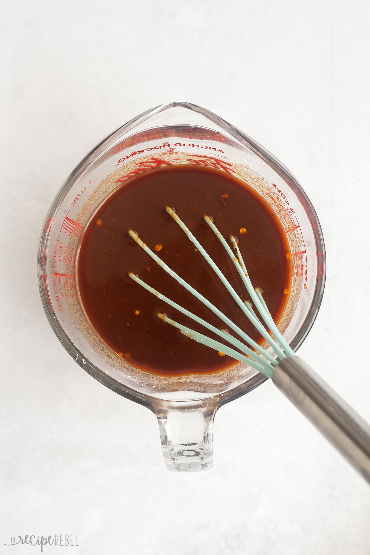 sauce for baked beans stirred together in glass measuring cup.