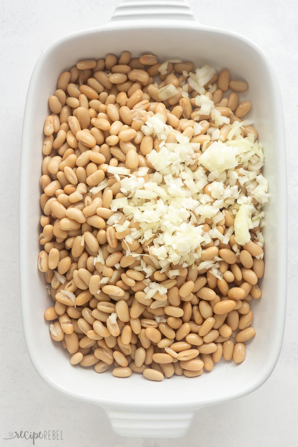 beans and onions in white baking dish.