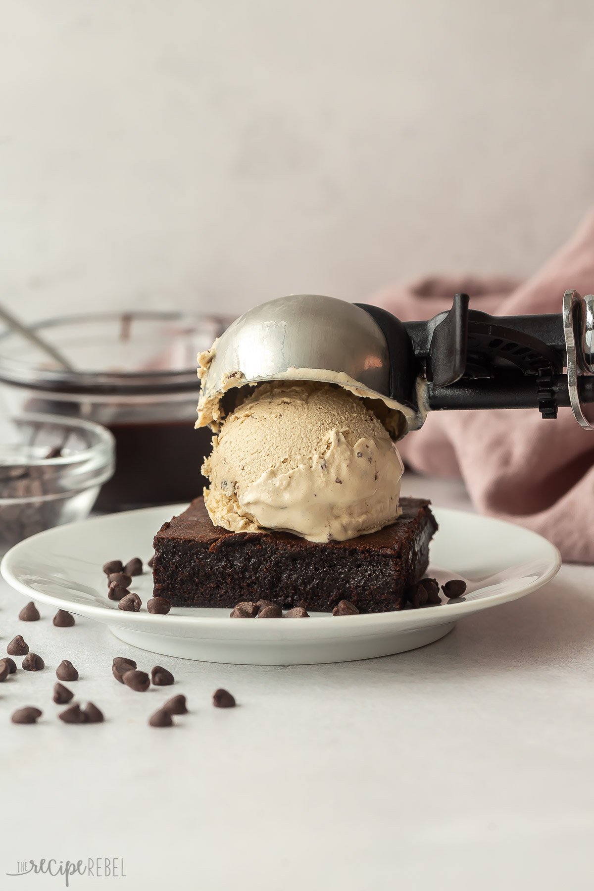 coffee chip ice cream scoop being placed on chocolate brownie.