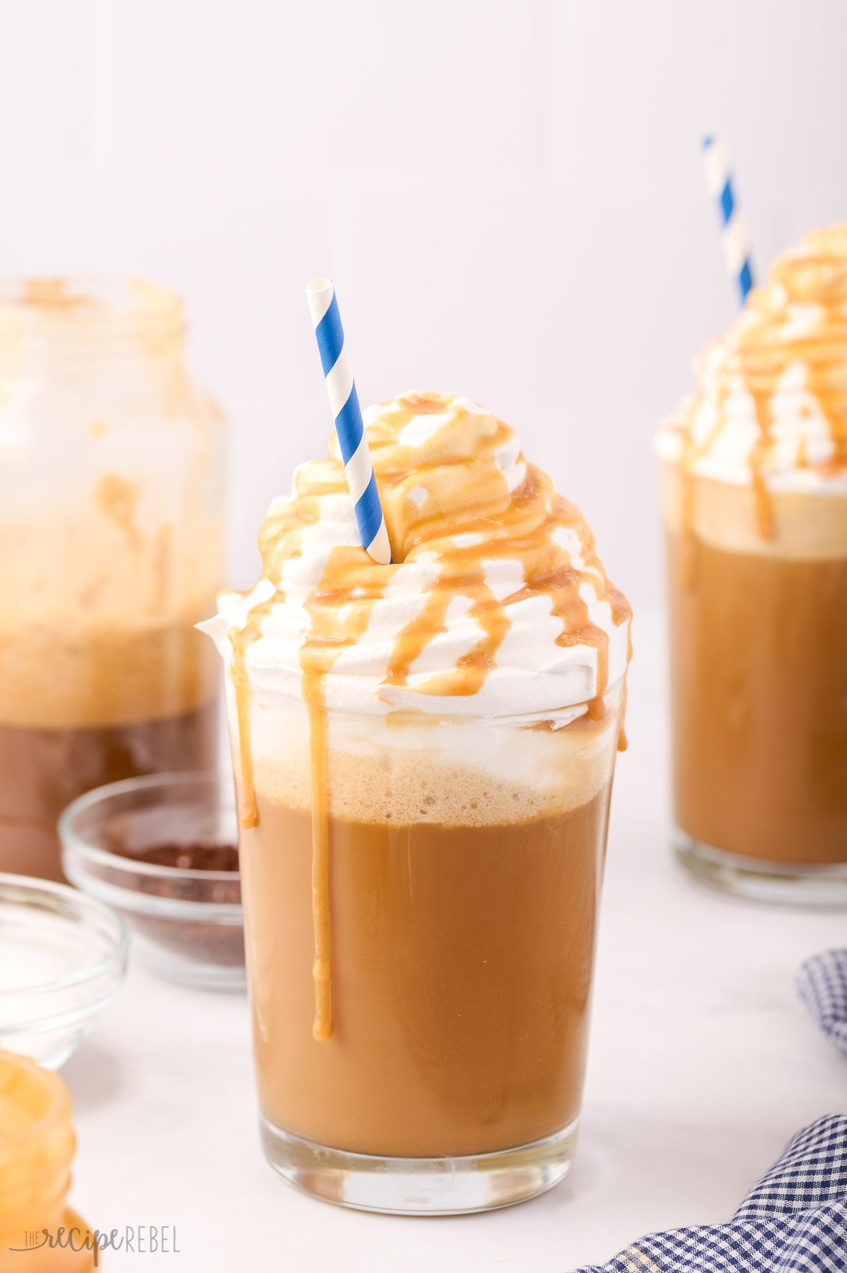 two glasses of caramel frappuccino with whipped cream and caramel sauce
