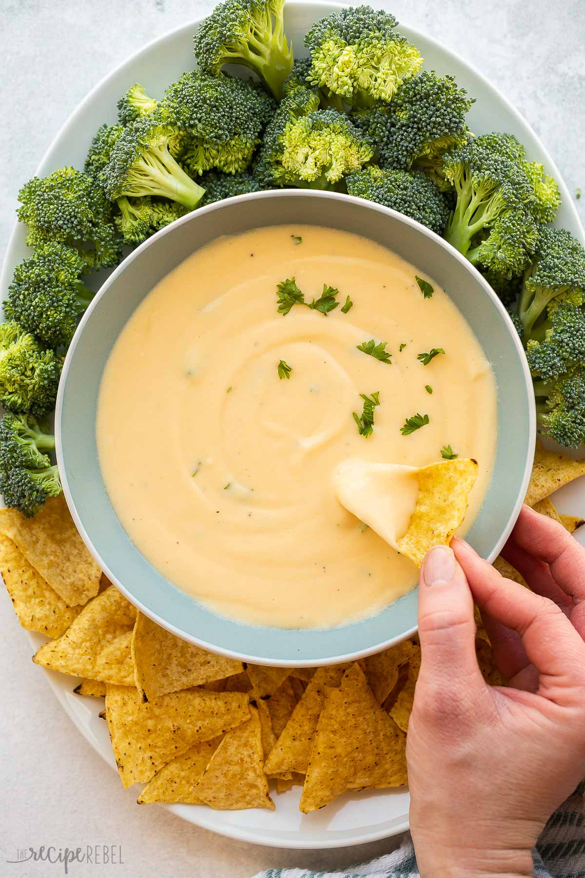 overhead image of a chip being dipped into cheese sauce