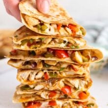 hand grabbing top quesadilla from a stack.