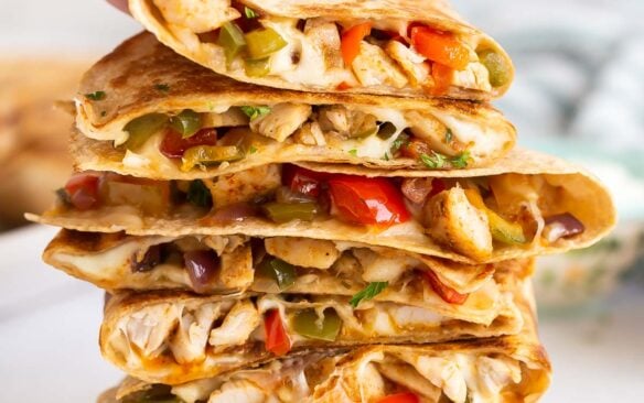 hand grabbing top quesadilla from a stack.