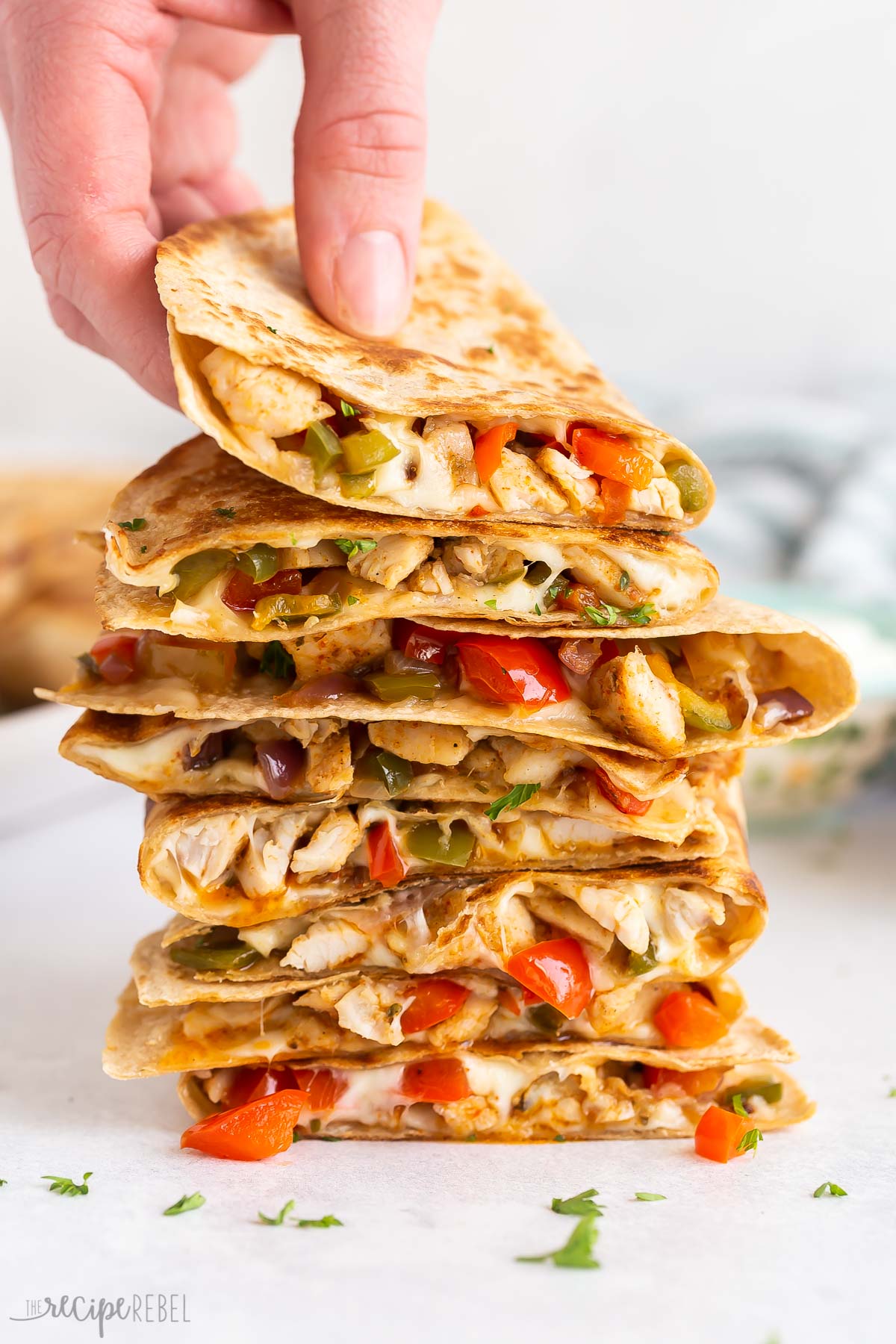 hand grabbing top quesadilla from a stack.