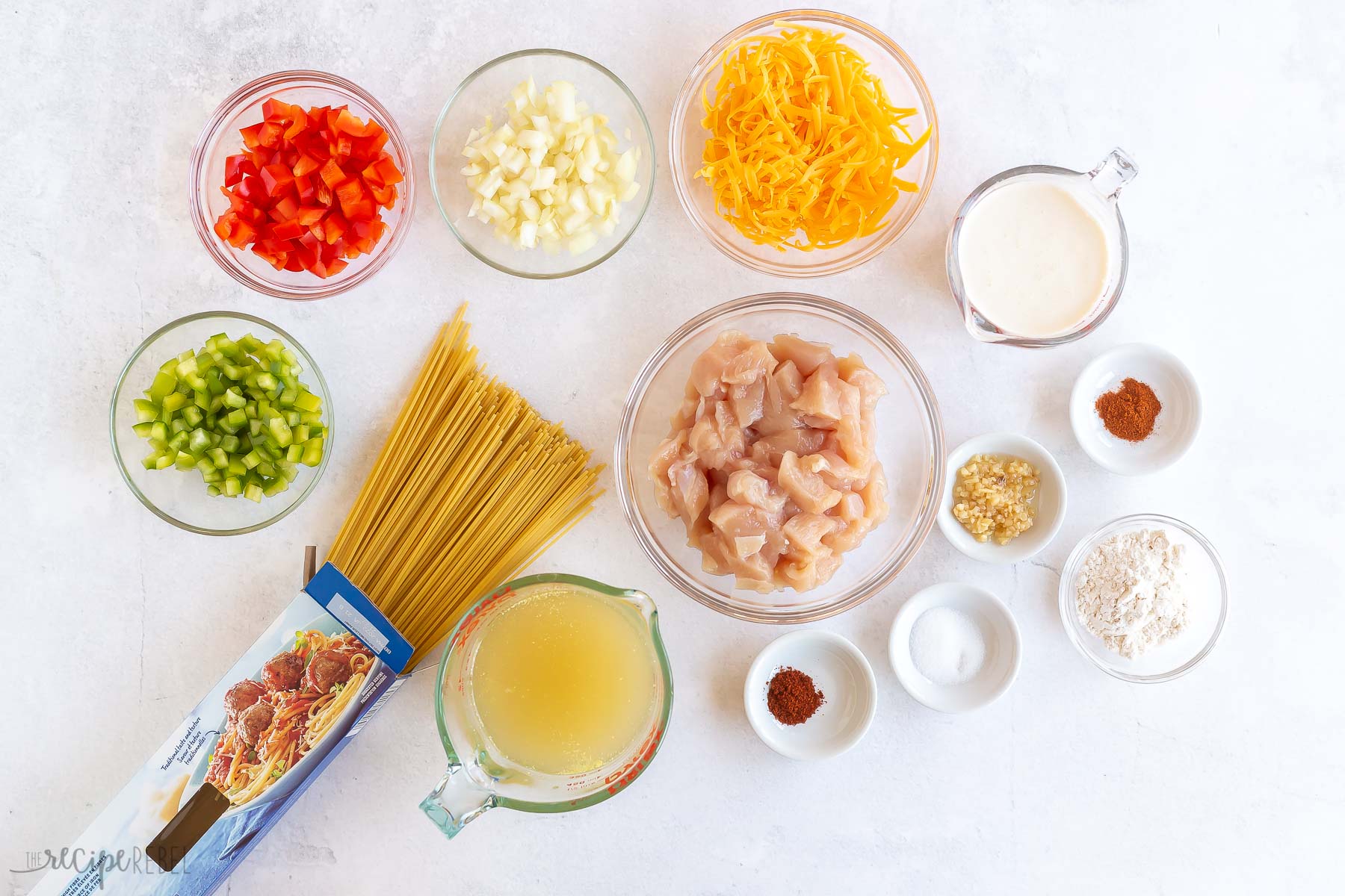 ingredients needed to make chicken spaghetti on white background.
