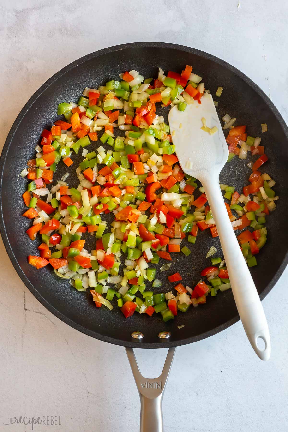 red and green peppers cooked down in skillet.