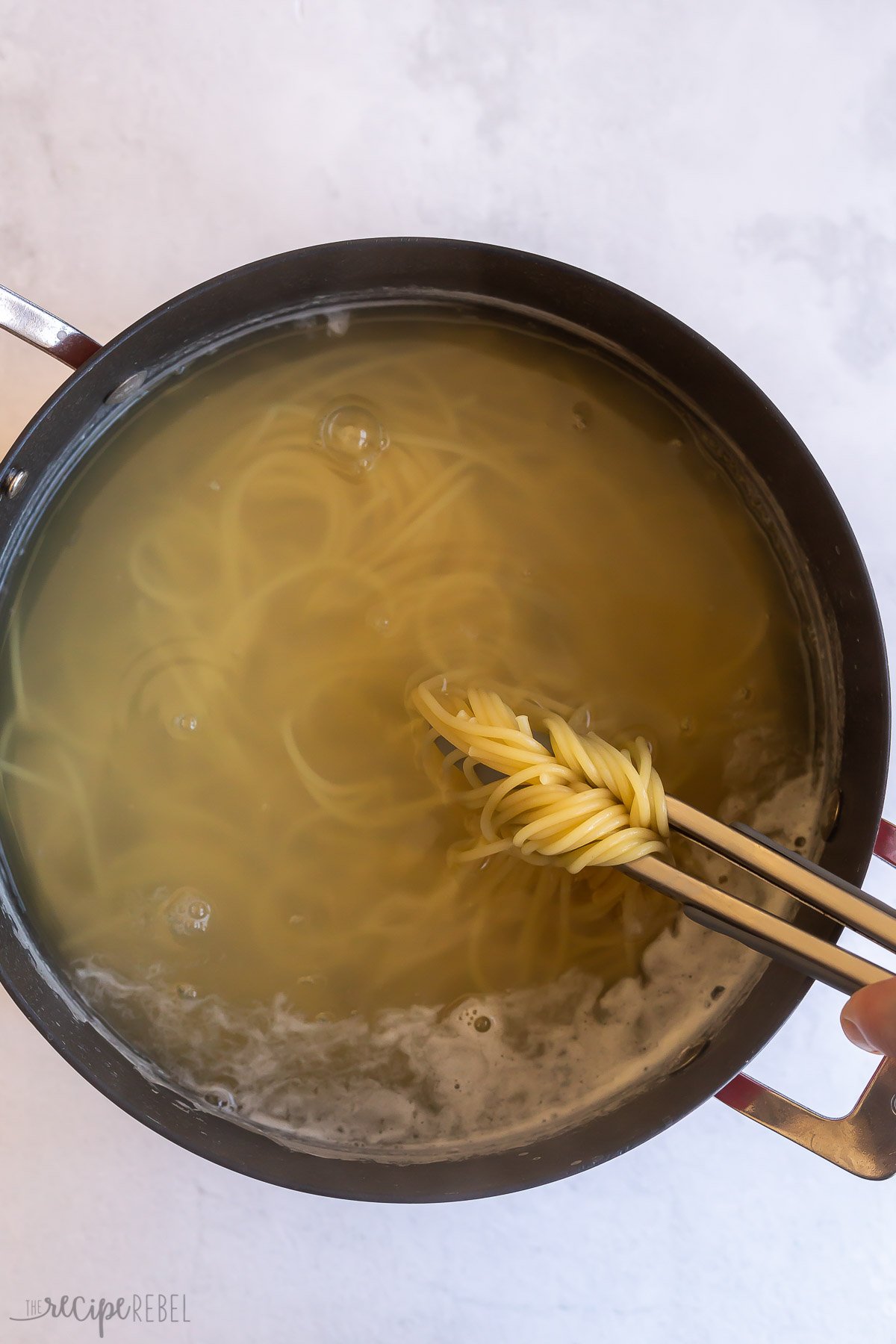 cooked spaghetti noodles in large black pot.