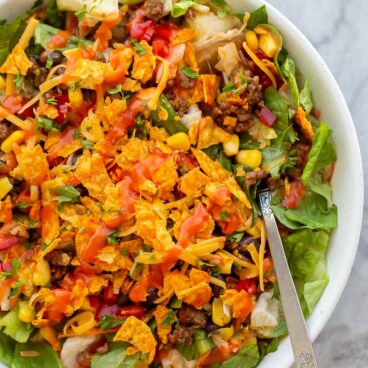 dorito taco salad in white bowl with catalina dressing on top