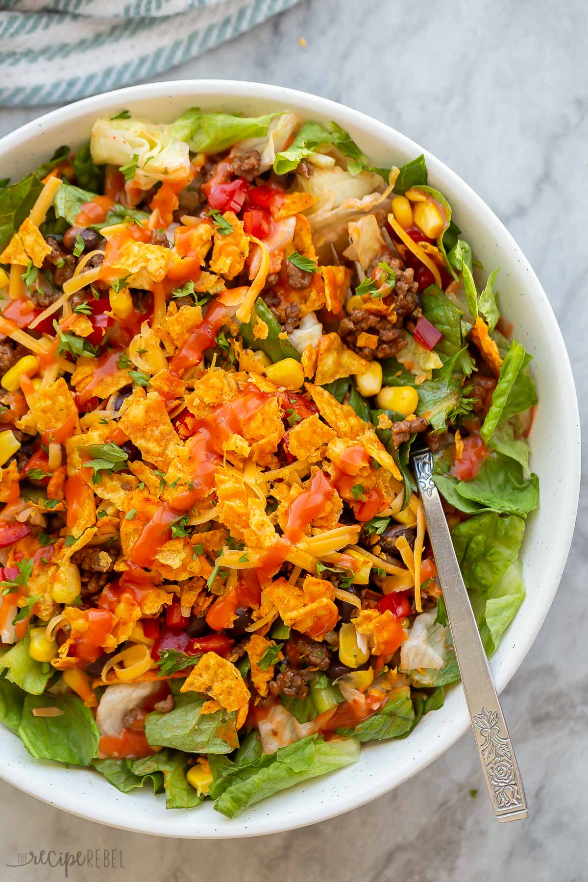 dorito taco salad in white bowl with catalina dressing on top