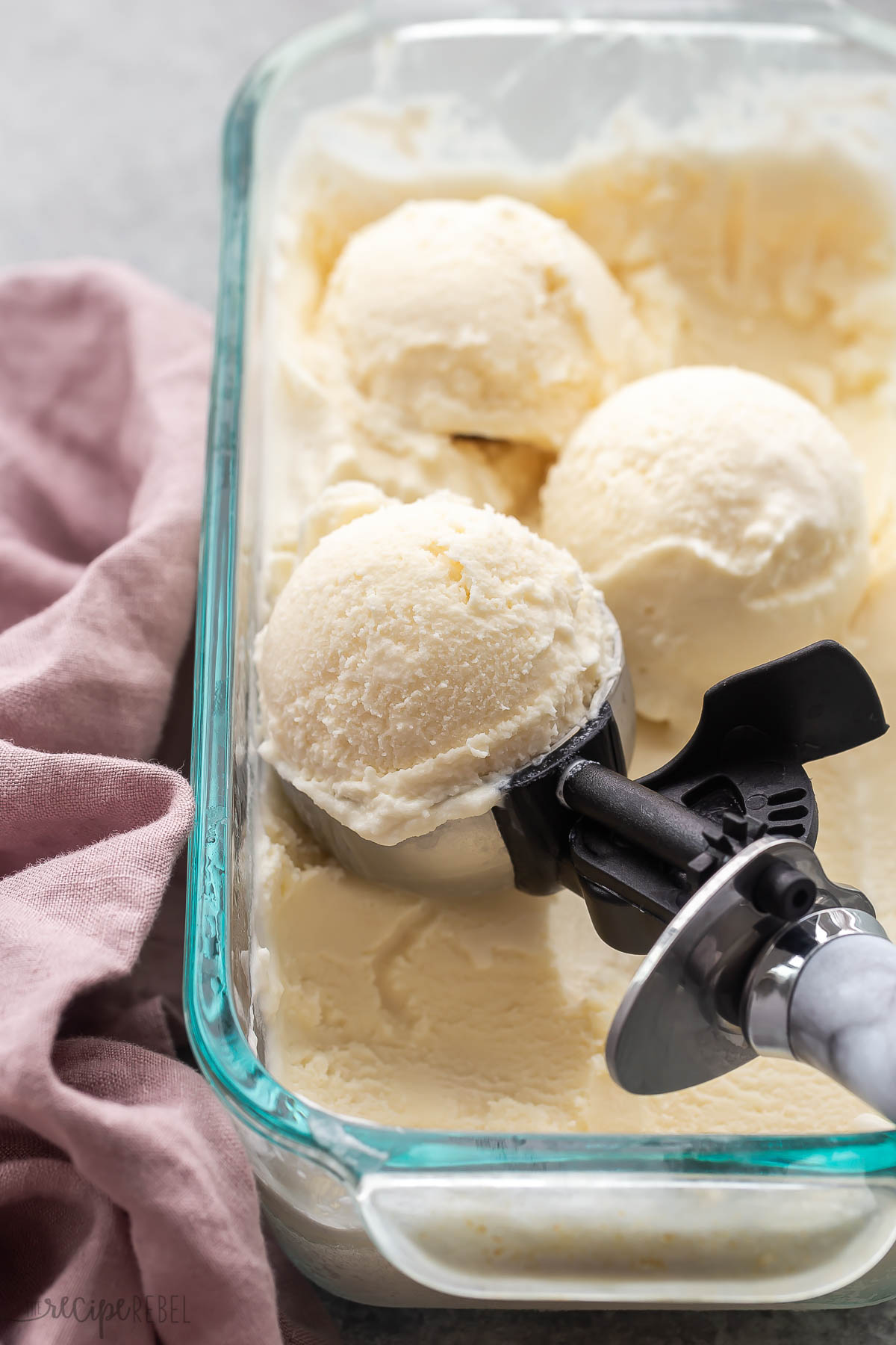three scoops of vanilla ice cream on top of pan of ice cream.