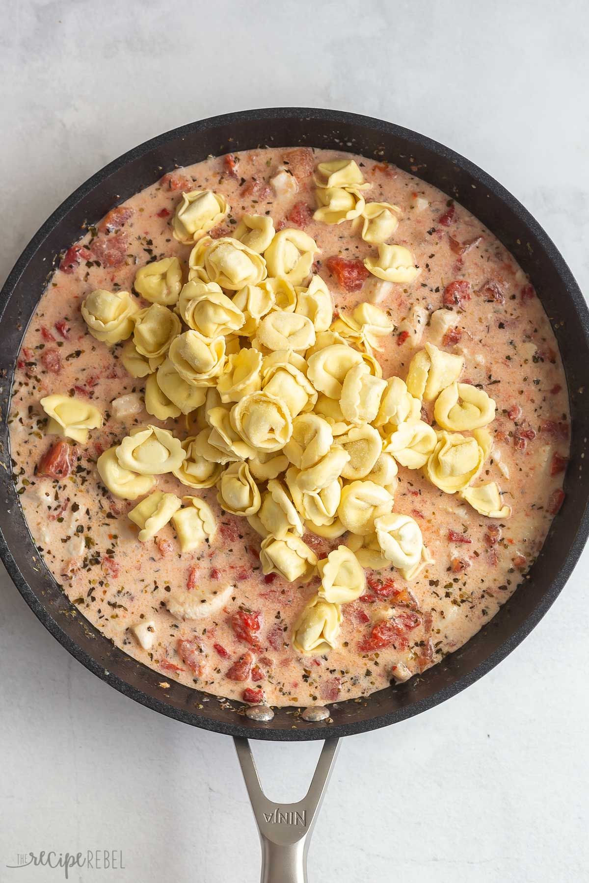 tortellini added to skillet with liquids.