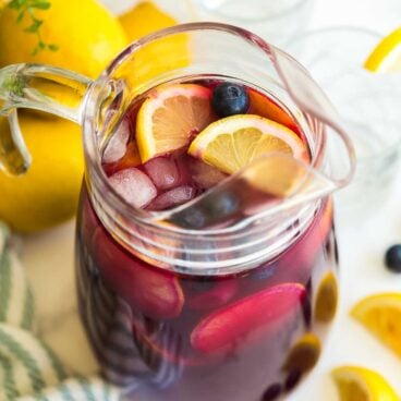 glass pitcher of blueberry lemonade with lemon slices and fresh blueberries