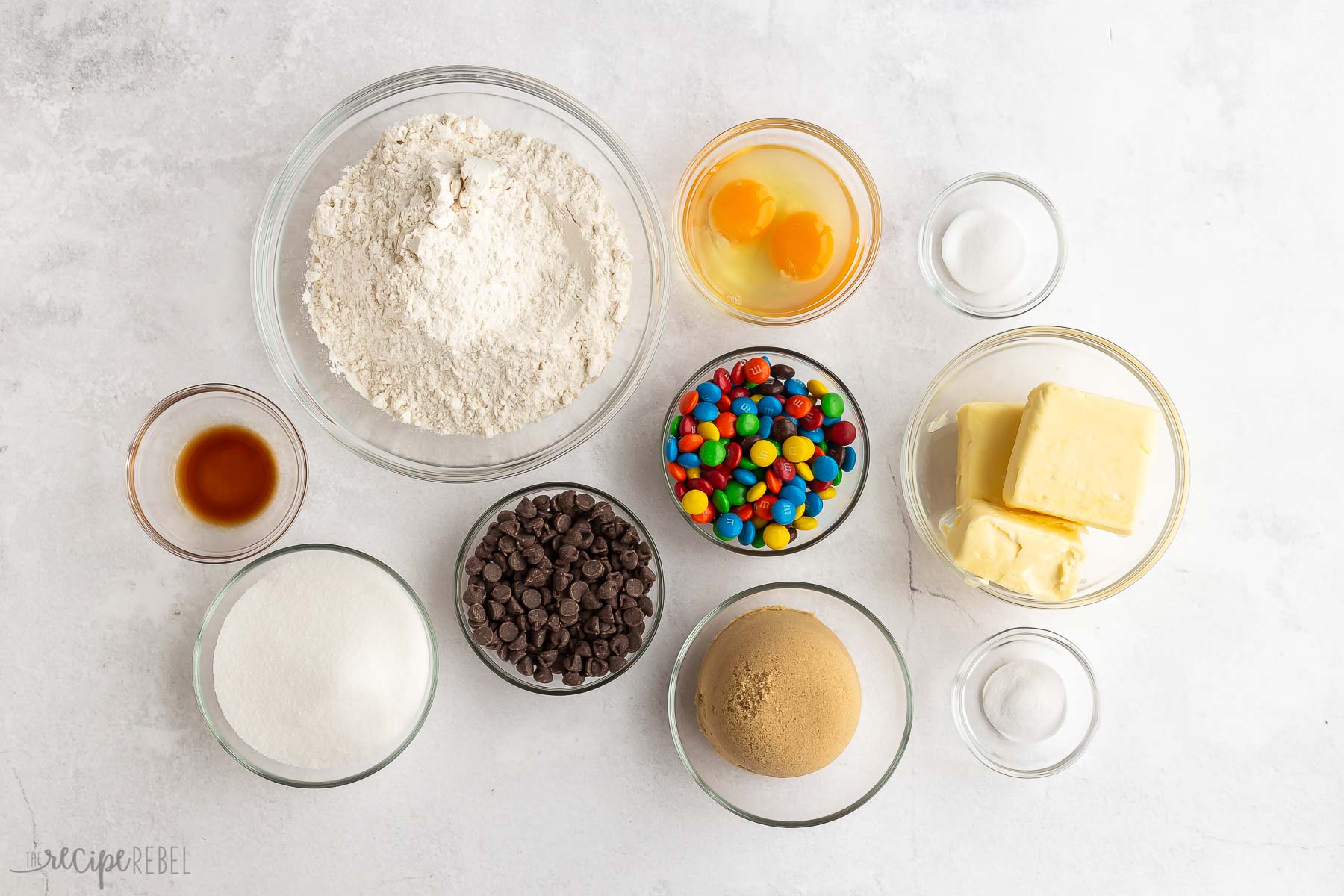 ingredients needed for M&M cookies on white background.