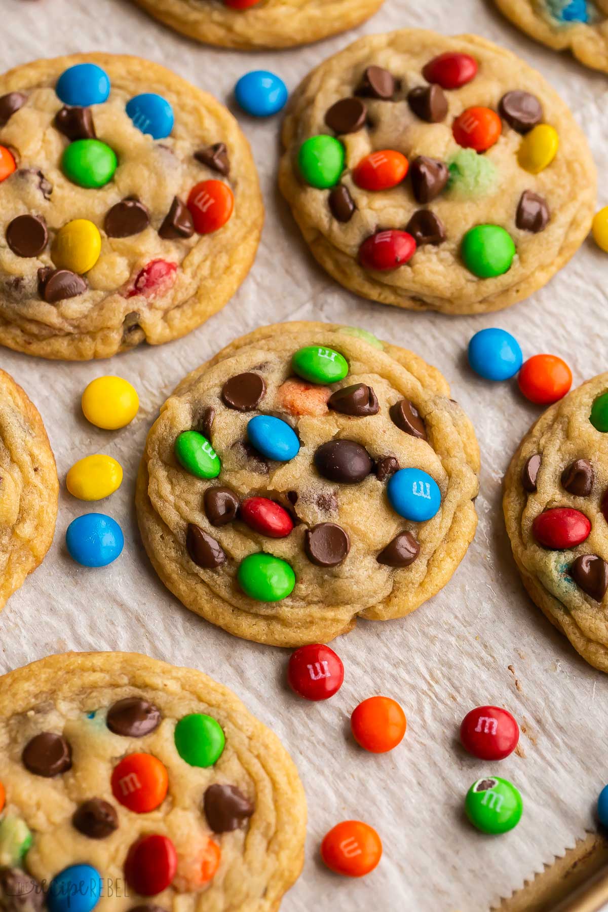 M and M cookie on baking sheet with M&Ms all around.