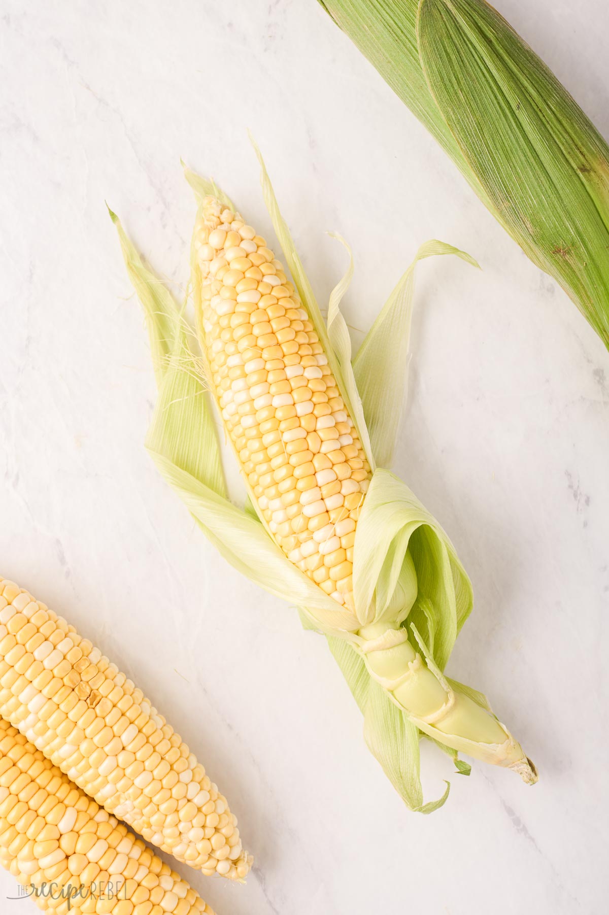 partially shucked cob of corn.