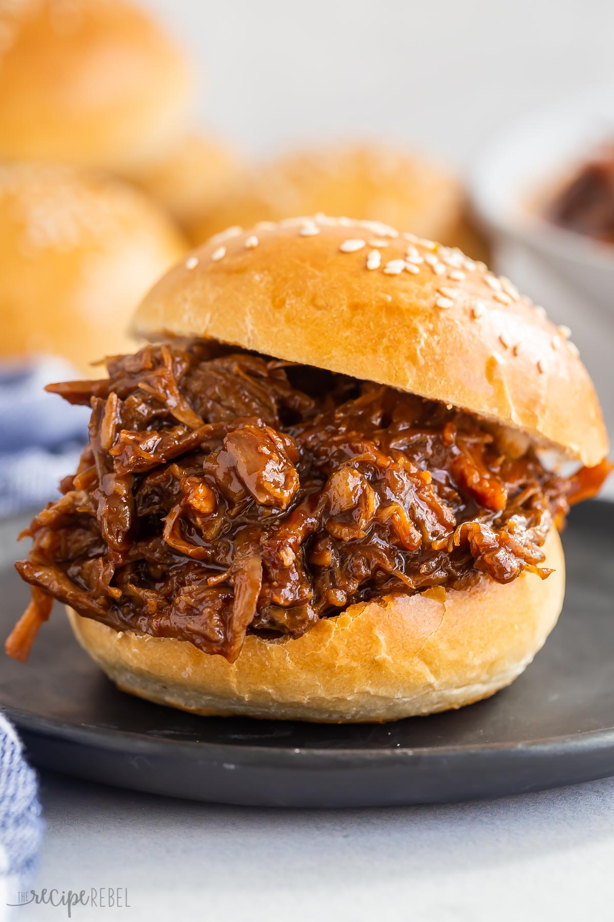 instant pot pulled pork on brioche bun on black plate.