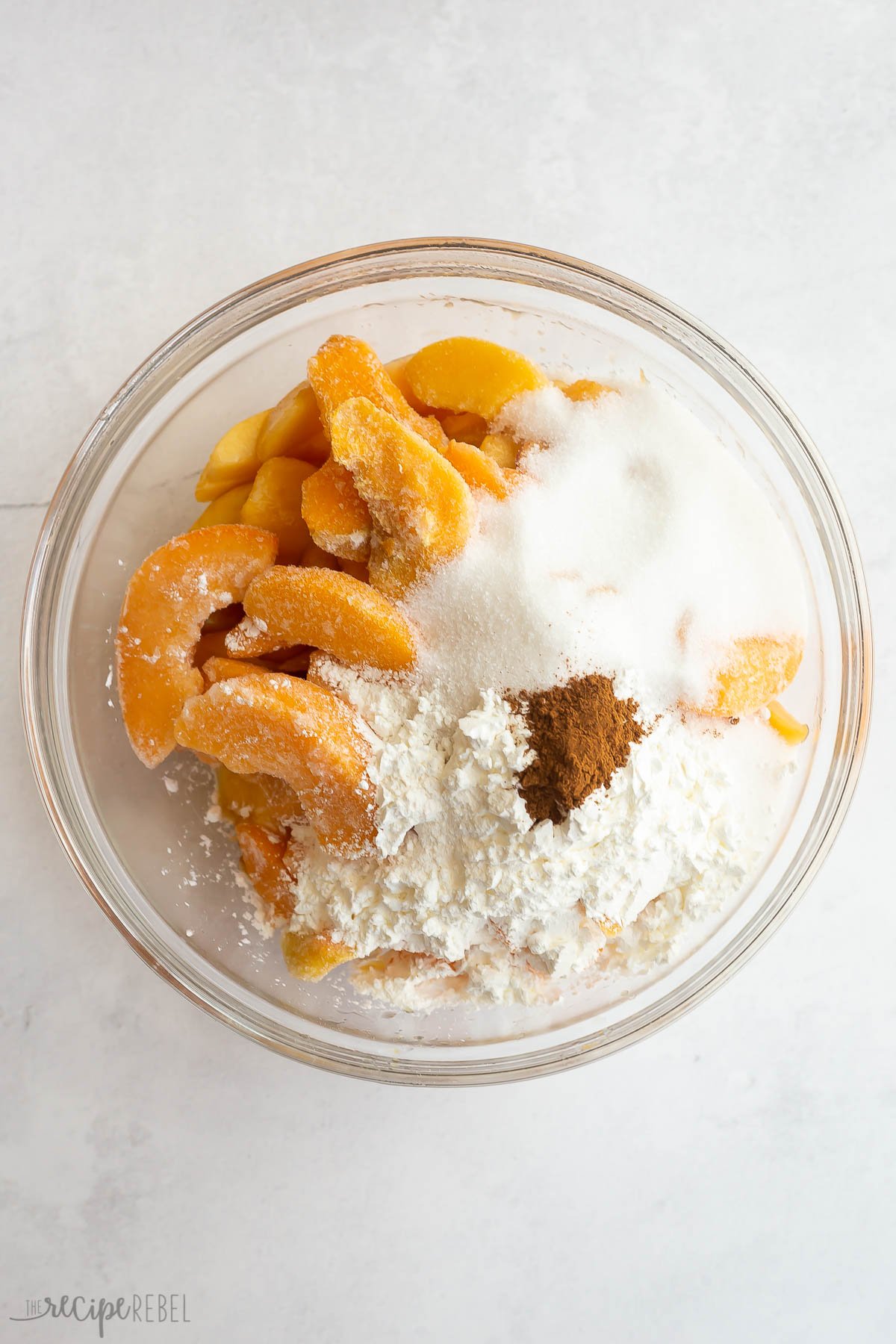 peaches with corn starch sugar and cinnamon in a bowl.