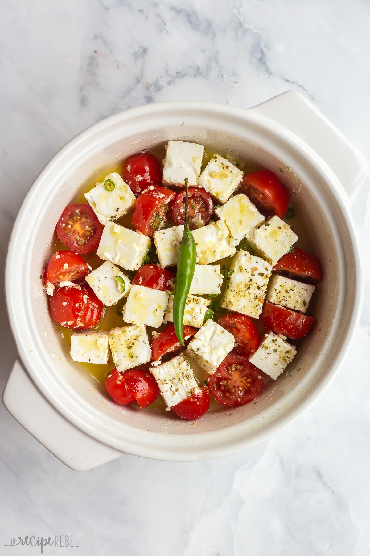 cubed feta cheese halved tomatoes and chilis ready to bake.